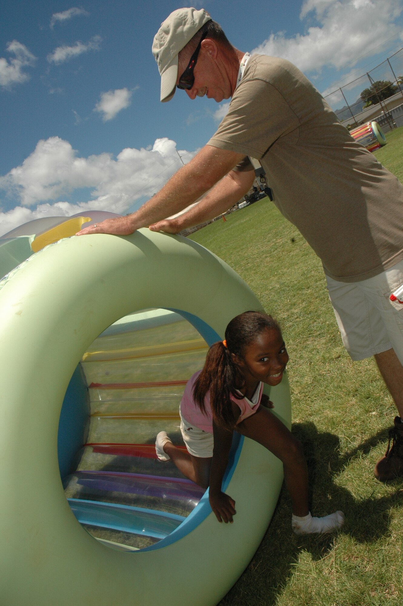 Tech. Sgt. Robert Brown, 624th Civil Engineer Squadron, helps Alexa out of the Giant Hamster Wheel at Makalapa Elementary School's Field Day, May 28-29. 624th CES is a part of the 624th Regional Support Group, Hickam Air Force Base, Hawaii. The 624th RSG has been involved with Makalapa since 2004 as part of the Hickam School Partnership program. (U.S. Air Force photo/Master Sgt. Daniel Nathaniel)