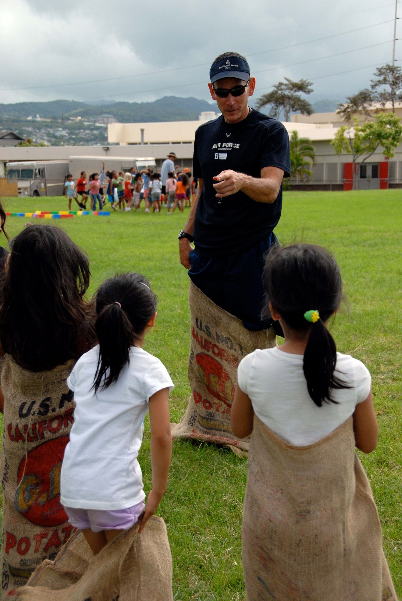 Master Sgt. Steve Adachi, 624th Regional Support Group safety manager, explains to his charges the safe and proper method of potato sack racing at Makalapa Elementary School's Field Day, May 28-29. The 624th RSG has been involved with Makalapa since 2004 as part of the Hickam School Partnership program. (U.S. Air Force photo/Staff Sgt. Jennie Chamberlin)