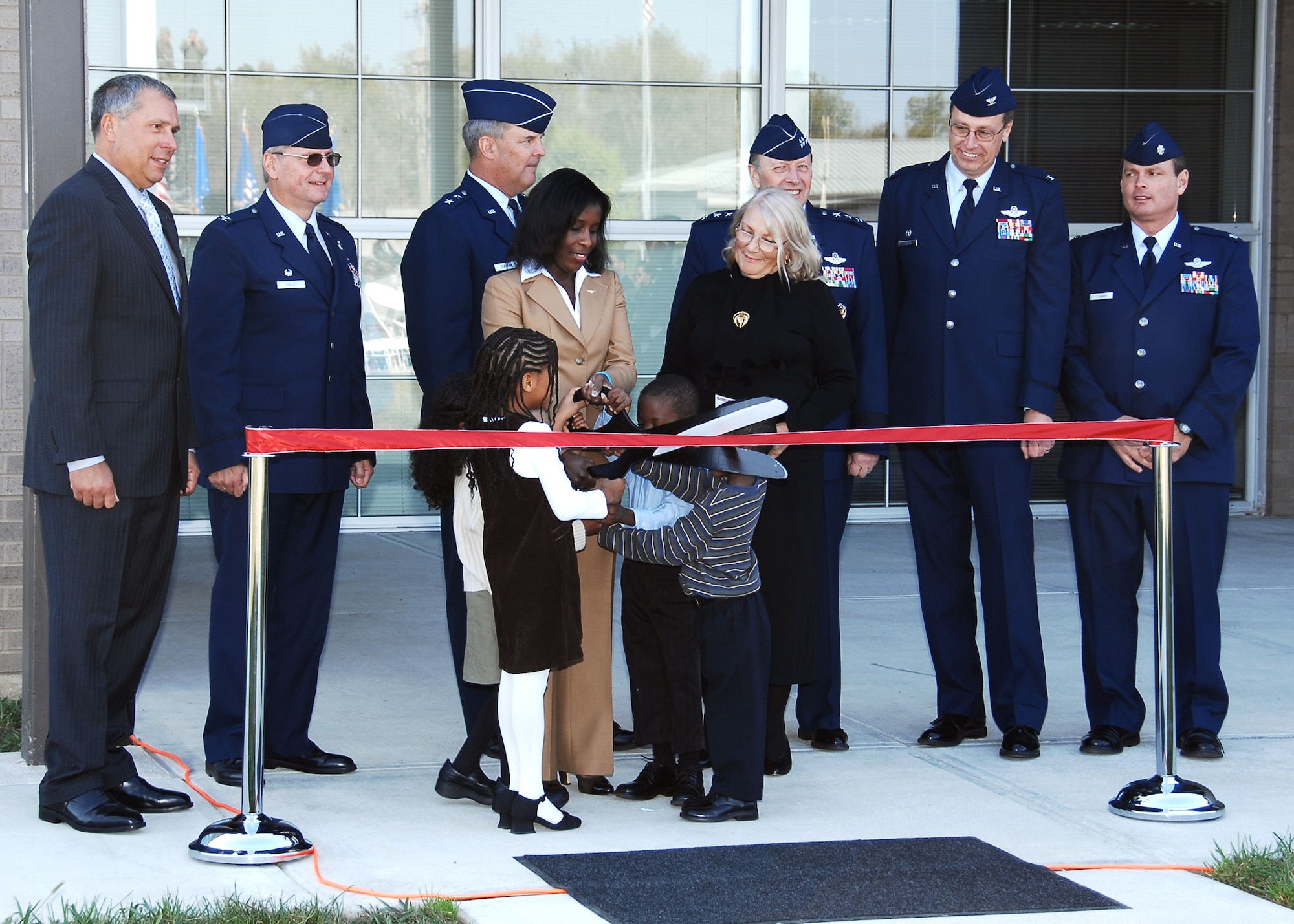WRIGHT-PATTERSON AFB, Ohio – Ms. Melodie Homer cuts the ceremonial ribbon during the Operations Building dedication Oct. 4, 2008, at the 445th Airlift Wing.  The building was dedicated in honor of her late husband, Maj. LeRoy W. Homer, Jr., who served with the wing from 1995 to 2000 and died Sept. 11, 2001.  Overlooking the ribbon cutting are Col. (ret.) Robert Shondel; Col. Roger Gallet, 445th Operations Group commander, Maj. Gen. Robert E. Duignan, Fourth Air Force commander; Maj. Homer’s mother, Ms. Ilse Homer; Lt. Gen. Charles E. Stenner, Air Force Reserve Command commander; Col. Stephen Goeman, 445th Airlift Wing commander; Lt. Col. Chris Clark, 445th Operation Group deputy commander; Maj. and Ms. Homer’s children, Laurel and Alden; and one other relative.  (Air Force photo/Ben Strasser)