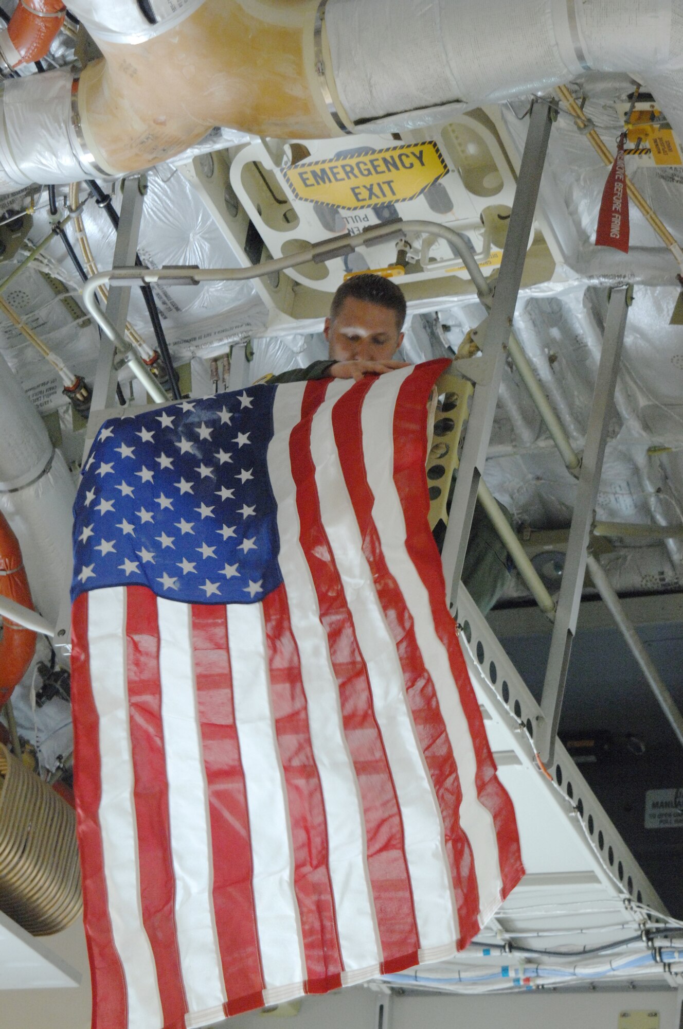 Technical Sgt. Ryan Benson, loadmaster, 729 AS, hangs a flag inside a C-17 aircraft. (U.S. Air Force photo by Senior Master Sgt. Kim Allain)