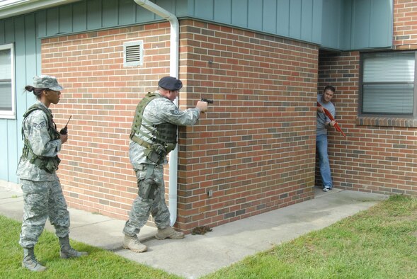 Staff Sgt. David Bloom, 43rd Security Forces Squadron, aims his pistol at an armed and disgruntled housing resident as part of Domestic Violence Response training Sept. 22 in Picerne Military Housing. The intense training involved scenarios in which trainees were outnumbered and sometimes attacked. In this scenario, Staff Sgt. Kevin Pressgrove jumped from behind the wall and tried to shoot Sergeant Bloom, but Sergeant Bloom fired a blank, neutralizing the threat and protecting himself. (U.S. Air Force Photo by Staff Sgt. Jon LaDue)