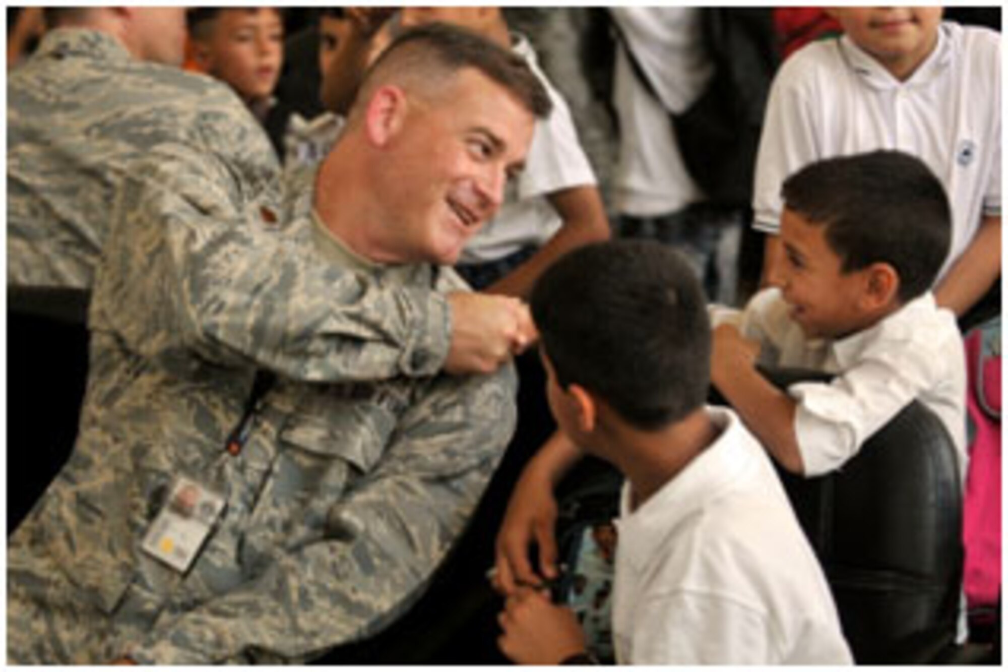 BAGHDAD, Iraq -- U.S. Air Force Reserve Maj. Andrew McDannold interacts with Iraqi children at the National Patriot Primary school inside the International Zone during a charity visit Sept. 22. U.S. Air Force members from the Coalition Air Force Training Team played games as well as gave out prizes for the winners. (Photo by U.S. Air Force Airman 1st Class Andrew Davis)