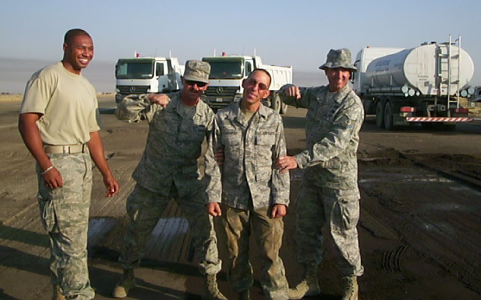 SEYMOUR JOHNSON AIR FORCE BASE, N.C. -- Senior Airman Curtis George (second from right) is promoted to the rank of staff sergeant in early September on Kirkuk's flightline. From left to right, Staff Sgt. Bobby Moore, Tech. Sgt. Gary Smith, Staff Sgt. George and Tech. Sgt. John Chartier. All are reservists with the 916th Civil Engineer Squadron and currently stationed in Iraq.