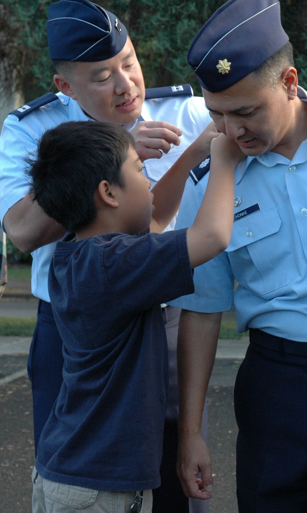 Lt. Col. Randall Honke, 48th Aerial Port Squadron commander, bends down so that his 10 year old son Gavin can pin on his new rank during a promotion ceremony Sept. 6, 2008 at Hickam Air Force Base, Hawaii. Colonel Honke has served as the 48 APS commander for one year and has been a member of the Air Force Reserve since 1990. Colonel Honke's wife and oldest son Alex were also present for the celebration. Colonel Honke is a native of Wahiawa, Hawaii. (U.S. Air Force photo/ Capt. Christy Stravolo)