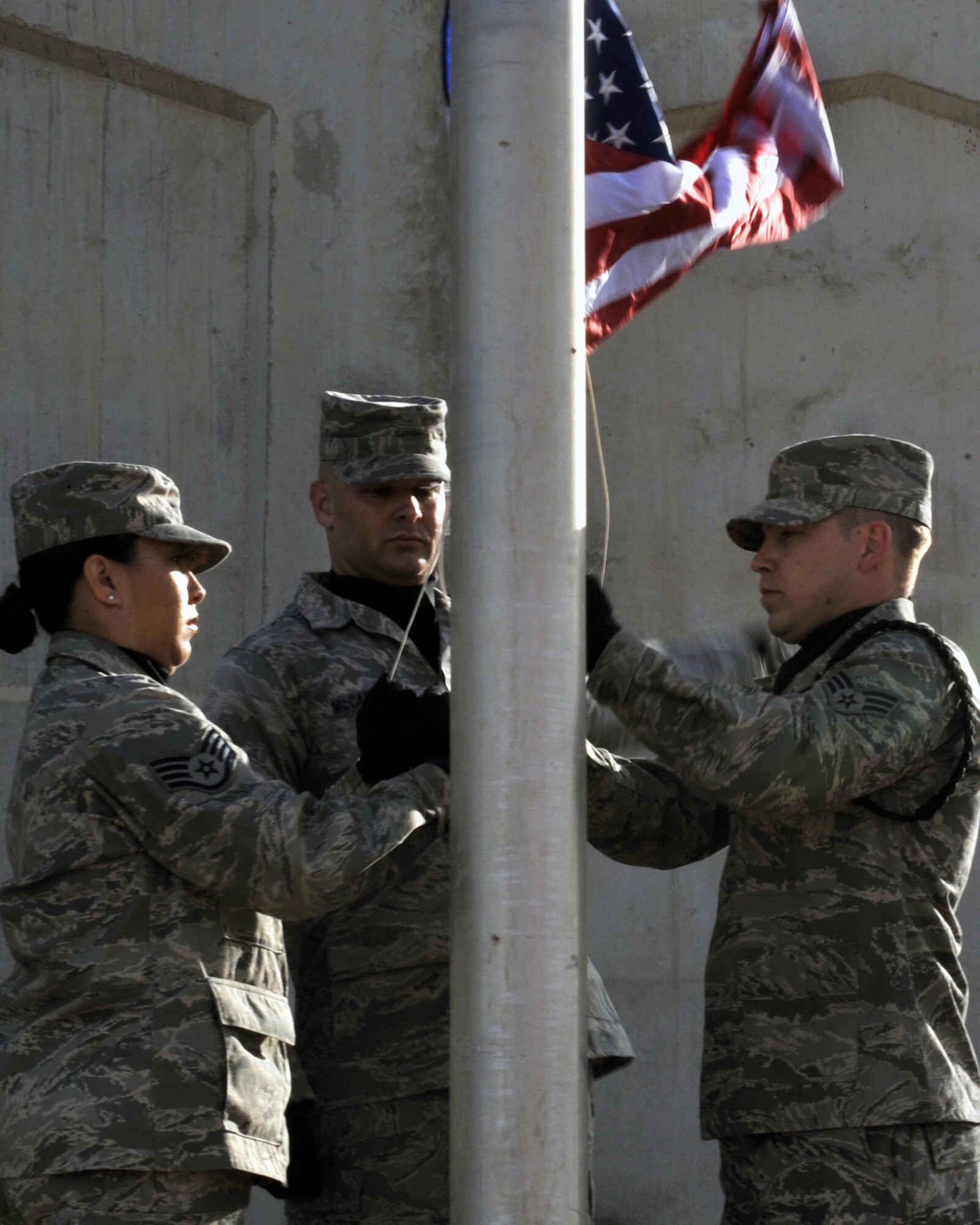 10/05/2008 ? SATHER AIR BASE, Iraq - Base Honor Guard members raise the flag, before returning it to half-staff, in honor of America?s firefighters who have given their lives in the line of duty. Firefighters and emergency medical personnel gathered here in observance of the National Fallen Firefighters Memorial Service, which is held annually in Emmitsburg, Md. Pictured from left to right are Staff Sgt. Amanda Mercado, Tech. Sgt. Joshua McCarty and Senior Airman Adam Latta. (U.S. Air Force photo by Master Sgt. Brian Davidson)