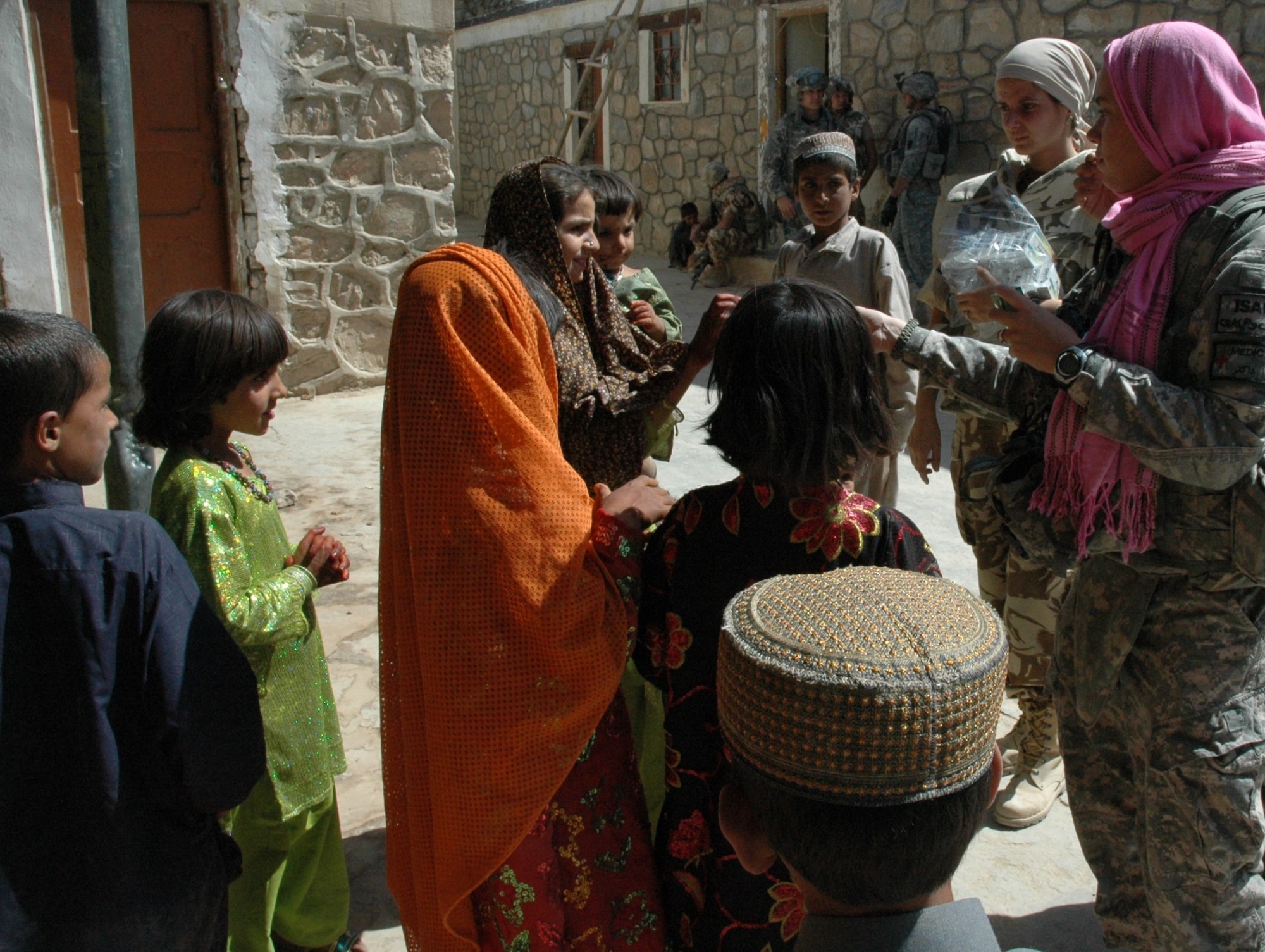 U.S. Air Force Senior Airman Felicita Torres-Perkins (right) and Romanian Staff Sgt. Nistorescu Ioana hand out vitamins to children in Jarullah village, Zabul province, Afghanistan, Oct. 2. Torres-Perkins is a medic for the Zabul Provincial Reconstruction Team and Ioana is a nurse practitioner in the 30th Mountain Battalion. Zabul PRT doctors and medics mentored the Romanians during the battalion’s first village medical outreach since arriving in country. (U.S. Air Force photo by Capt. Jean Duggan)