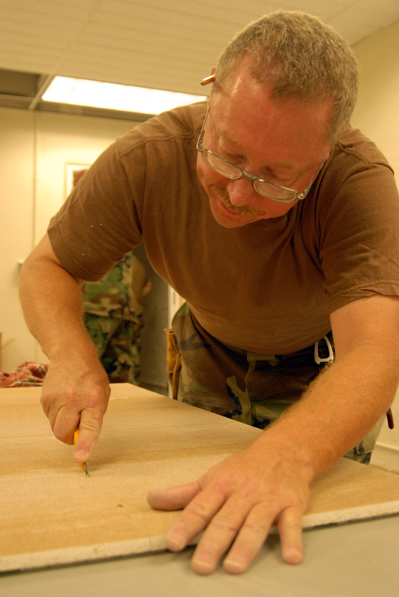 Master Sgt. Larry Broyles trims ceiling tile during a facilities upgrade at the Mintos Armory. (Photo by Senior Airman Jason Ketterer, Kentucky Air National Guard.)