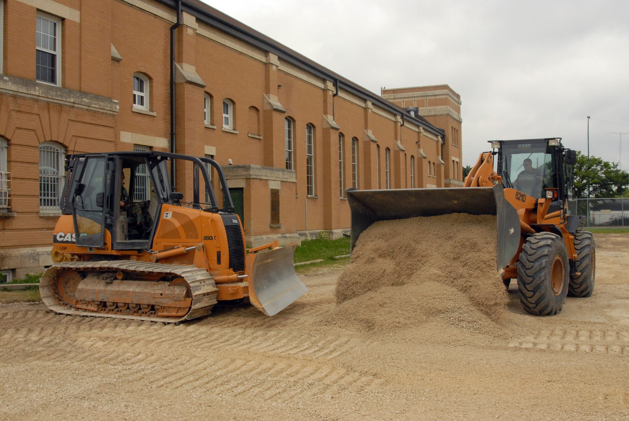 Heavy equipment operators work together to move gravel and earth to construct a parking lot at the Fort Garry Horse Armory. (Photo by Senior Airman Jason Ketterer, Kentucky Air National Guard.)