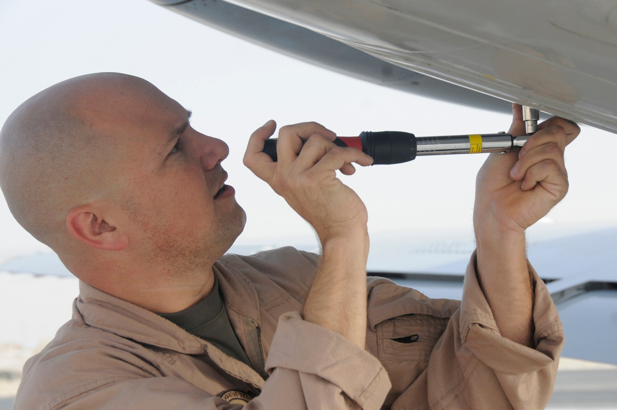 Sgt. Joshua Shirley, ordinance technician assigned to Marine Transportation Squadron 1, uses a scaffold wrench to close the compartment of a UC-35 that was loaded with flares Oct. 3, 2008, at an undisclosed air base in Southwest Asia.  The UC-35 provides senior warfighting commanders and their staffs executive transportation to meet and concord with other governments in support of Operations Iraqi and Enduring Freedom and Joint Task Force-Horn of Africa. Sergeant Shirley, a native of Columbia, S.C., is deployed from Marine Corps Air Station Cherry Point, N.C. (U.S. Air Force photo by Staff Sgt. Darnell T. Cannady/Released)