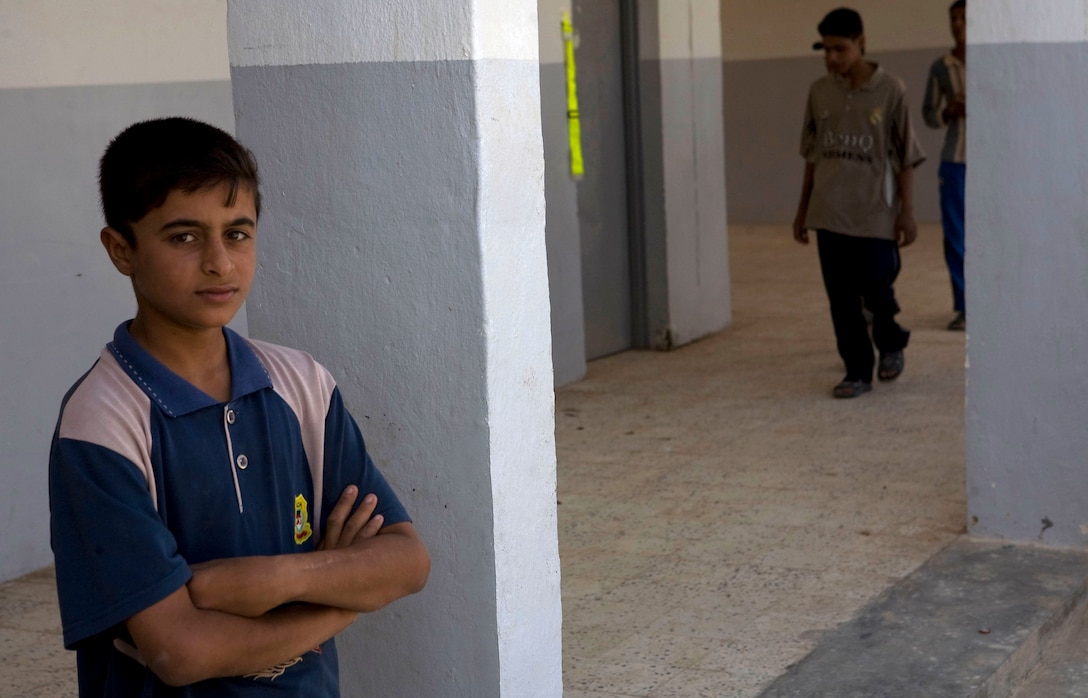 KARMAH, Iraq (October 5, 2008)-An Iraqi boy awaits the ribbon cutting ceremony as his peers look through the finished school at the Shohabi Boys and Girls primary school reopening, October 5, in Karmah. (Photo by Lance Cpl. Achilles Tsantarliotis)