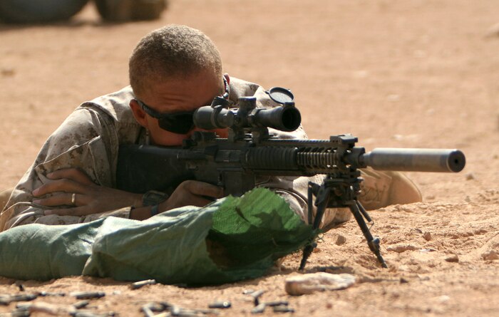 Sgt. Ernest C. Browne, designated marksman for Security Forces Platoon, Headquarters and Service Company, 1st Light Armored Reconnaissance Battalion, Regimental Combat Team 5, takes aim on targets down range at Camp Korean Village, Iraq, Oct. 5. "Our weapons are the most important piece of gear we have, so taking the time to get it ready is vital to whatever mission we have," said Browne.::r::::n::