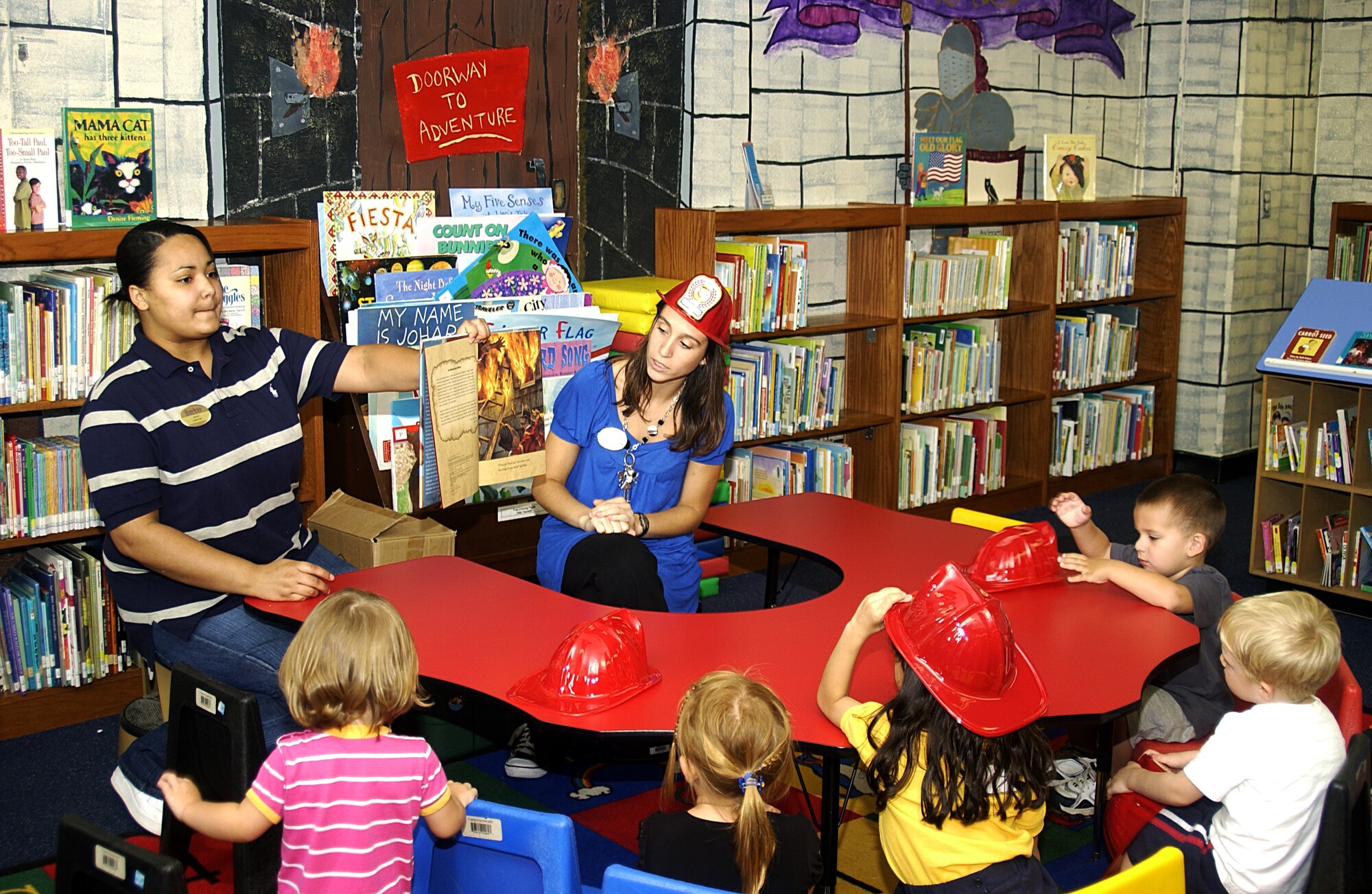 ANDERSEN AIR FORCE BASE, Guam - Christina Wray and Alicia Jackson, both librarian aides for the 36th Force Support Squadron, read children the book "New York's Finest" during Story Time at the Andersen Library Oct. 1. (U.S. Air Force photo by Airman 1st Class Carissa Wolff)                                 