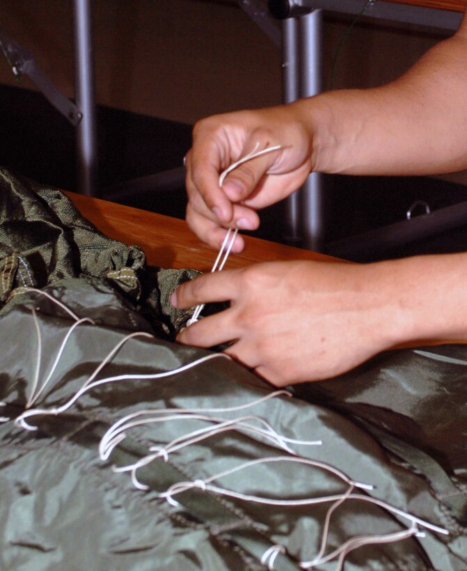 Airman 1st Class Raul Hernandez applies tension to and squares the lines on a 22-foot extraction chute. Aerial delivery training is performed at least weekly at Cannon Air Force Base, N.M. It prepares the aircrew for resupply missions for special operations forces when an airfield cannot be used. Airman Hernandez is assigned to the 27th Special Operations Logistics Readiness Squadron. (U.S. Air Force photo/Airman 1st Class Danielle Martin)