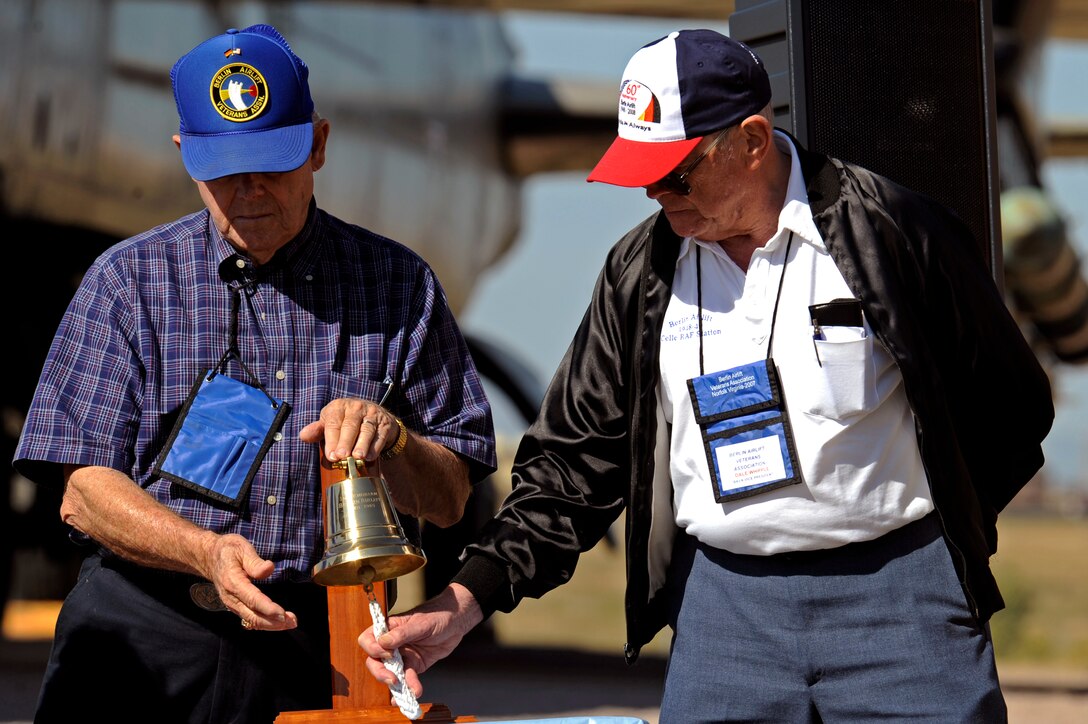 Members of the Berlin Airlift Veterans Association ring a bell after names of the fallen Airmen from the Berlin Airlift are announced at the South Dakota Air and Space Museum, Oct. 3. Thirty-one names were called, followed by three-gun salute and a bugler playing taps. (U.S. Air Force photo/Airman Matthew Flynn)