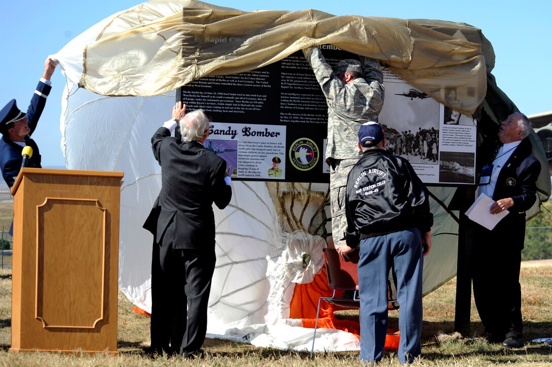 Members of the Berlin Airlift Veterans Association and Ellsworth Airmen unveil an outdoor plaque to commemorate the Berlin Airlift's 60th anniversary at the South Dakota Air and Space Museum, Oct. 3. The plaque showcases a brief history of the Airlift and several photos from the operation, which spanned from June 24, 1948 to May 12, 1949. (U.S. Air Force photo/Airman Matthew Flynn)

