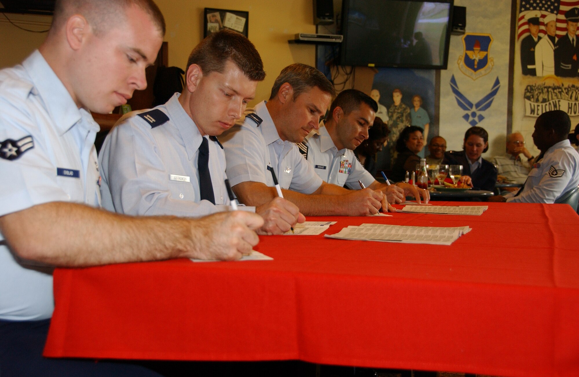 From left: Airman 1st Class Benjamin Ekblad, 71st Flying Training Wing command post, Capt. Kris Ostrowski, wing Combined Federal Campaign project officer, Col. Mark C. Nowland, 71st FTW commander, and Chief Master Sgt. Ruben Gonzalez, 71st FTW command chief, sign their CFC forms at the wing CFC kick-off luncheon at the Vance Collocated Club Oct. 6. (U.S. Air Force photo by Staff Sgt. Brian Hill)            