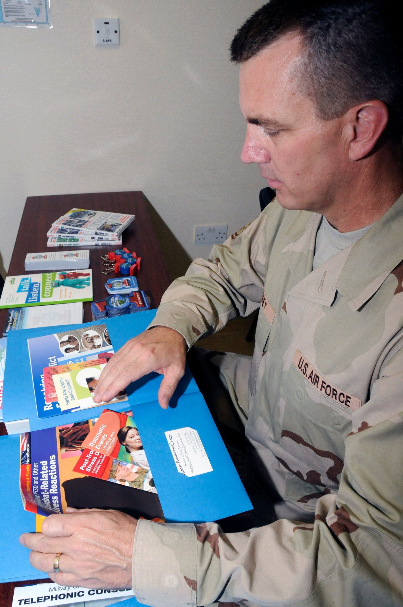 Senior Master Sgt. Grant Embrey puts together an Airmen Readiness Center folder which contains information on many topics beneficial to Airmen in the area of responsibility. Sergeant Embrey is the 379th Expeditionary Force Support Squadron superintendent of the Airmen Readiness Center. (U.S. Air Force photo/Staff Sgt. Darnell T. Cannady)