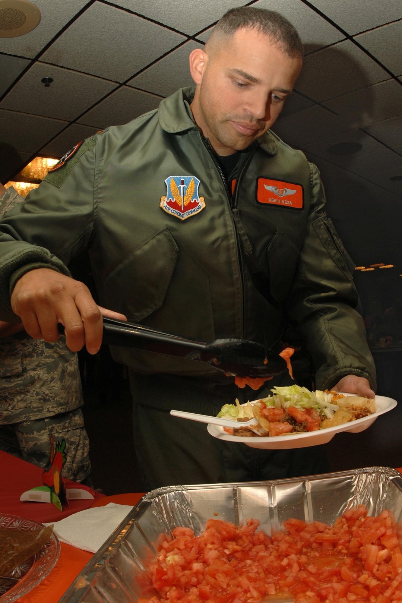 OFFUTT AIR FORCE, Neb. -- 2nd Lt. Kevin Vega, 338th Combat Training Squadron, adds tomatoes for a taco during the annual Hispanic American Heritage Month food tasting at the Offutt AFB Community Center Oct. 1. Hispanic American Heritage Month began Sept. 15 and ends Oct. 15. (U.S. Air Force Photo By Charles Haymond)