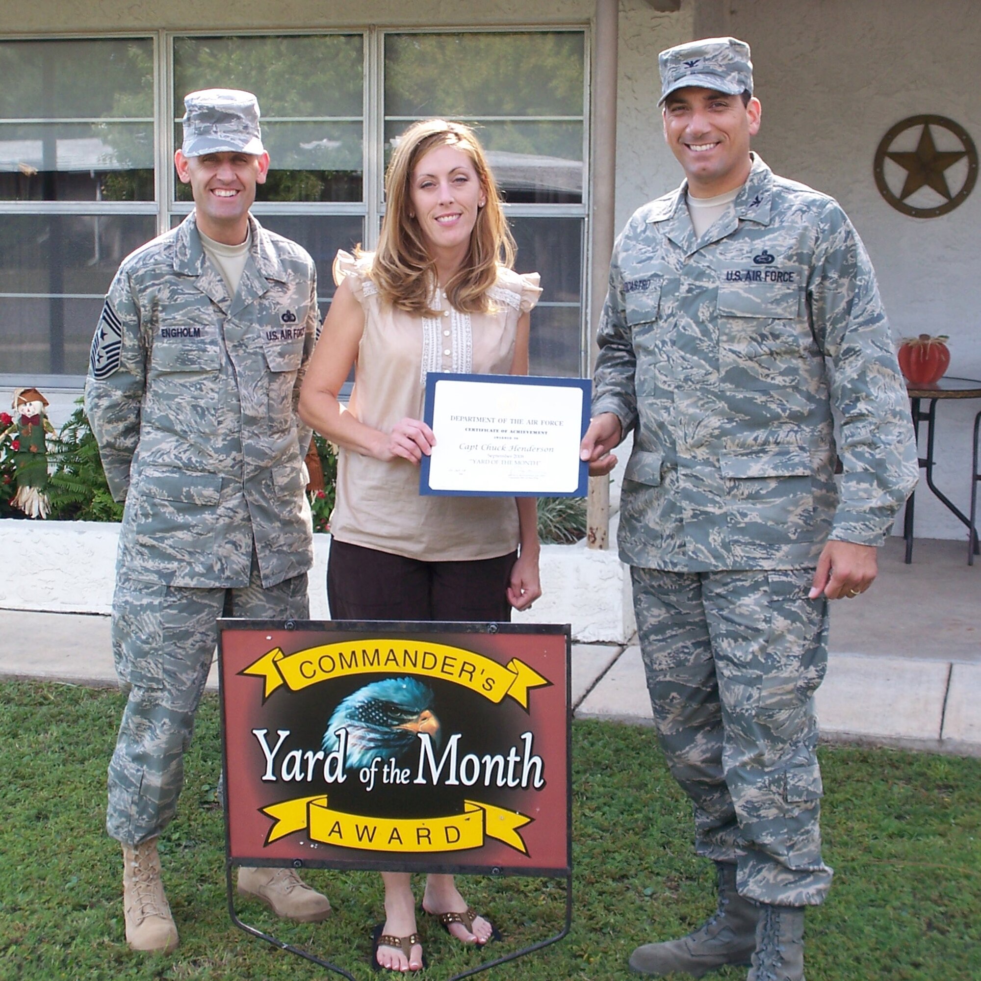 Col. Rick LoCastro, 96th Air Base Wing vice commander, presents Suzette Henderson, wife of Capt. Chuck Henderson, 16th Special Operations Group,with a certificate of award in the Yard of the Month competition. Command Chief Master Sgt. Troy Engholm was also present. The Hendersons also received two $25 gift cards. (USAF photo by Timothy Crews) 