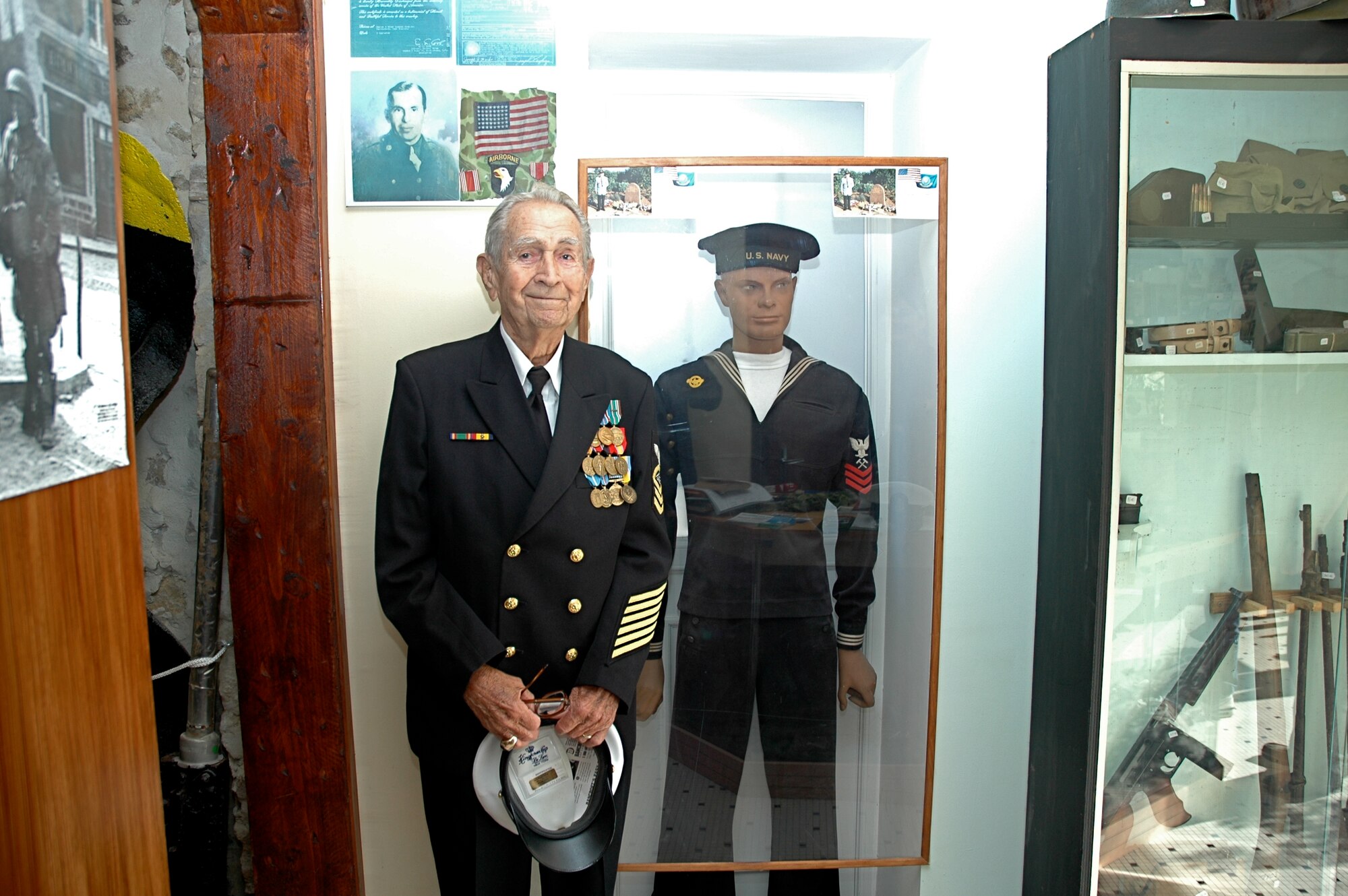 Retired Chief Radioman Joe Pearson poses in the D-Day landing museum in the small French town of Saint Marie du Mont near Utah Beach where the Chief landed abord LST-306 during the D-Day invasion on June 6, 1944. (Photo courtesy of Chief Petty Officer Steven L. Schultz)