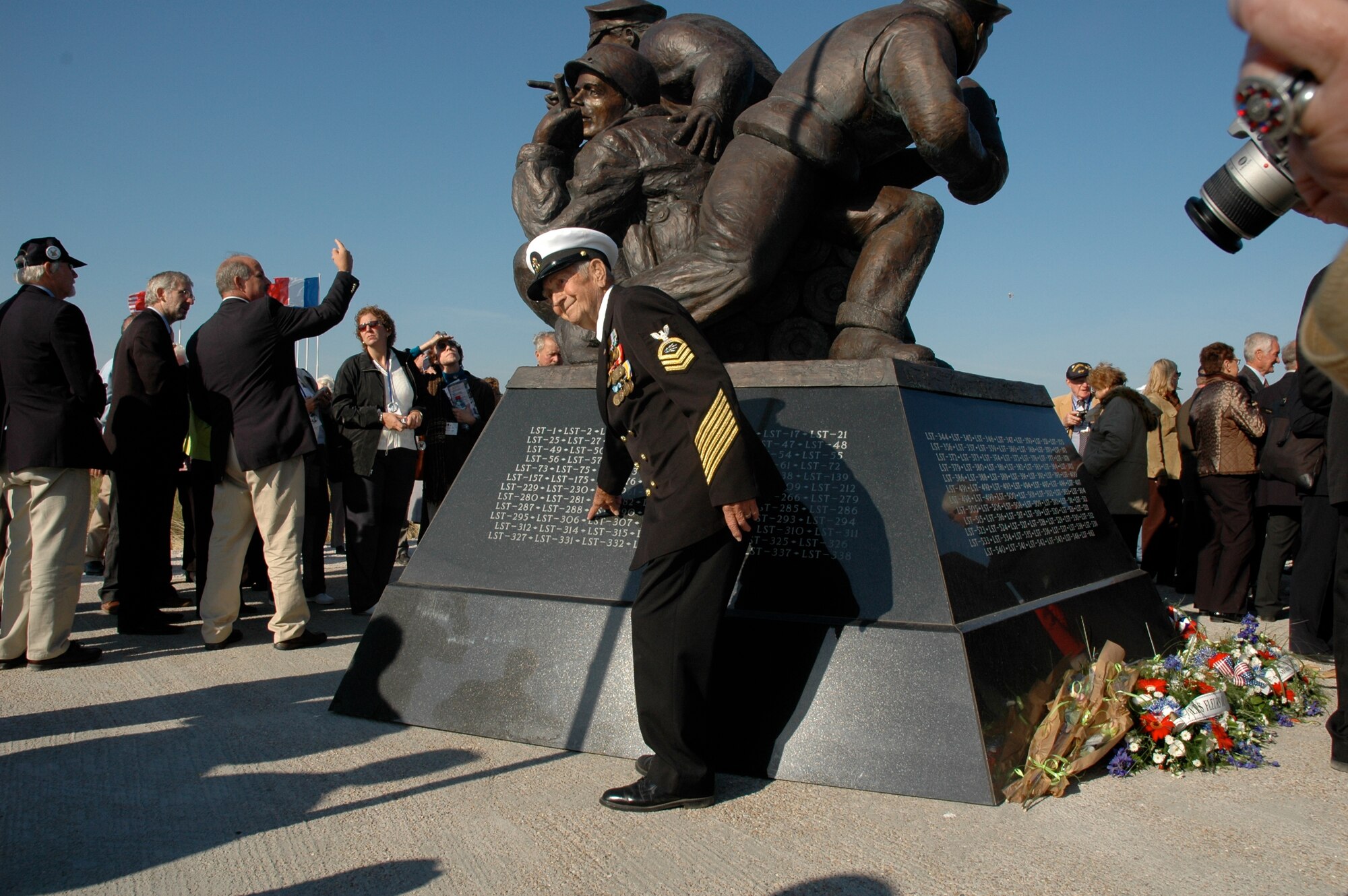 Retired Chief Radioman Joe Pearson points to the name of his ship, LST 306 in which he landed on Utah Beach in Normandy, France on D-Day 1944.  As he pointed, ceremony participants and French civilians - some of which had been children during the invasion - snapped his photo. He was returning to the beach for the first time since that day to participate in the dedication of the U.S. Navy Memorial on September 27, 2008.  The memorial, sponsored by the Naval Order of the United States, honors all who participated in Operation Neptune, the Naval part of Operation Overlord, the invasion of France on June 6, 1944.  (Photo courtesy of Chief Petty Officer Steven L. Schultz)