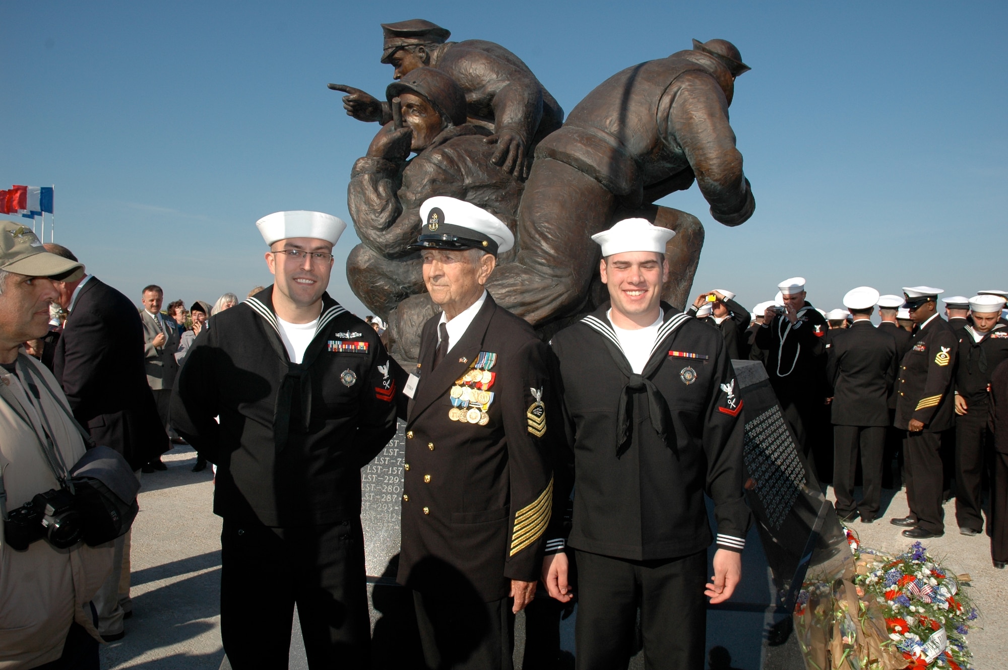JIOCEUR Analytic Center Navy Petty Officer 2nd Class Morgan D. Olson and Petty Officer 3rd Class Kurt Pierce stand with retired Chief Radioman Joe Pearson in front of the U.S. Navy memorial at Utah Beach near Saint Marie du Mont, France.  The memorial was dedicated on September 27, 2008 and was sponsored by the Naval Order of the United States.  For Chief Pearson it was his second visit to this beach.  His first under far different circumstances was on June 6, 1944 during the Normandy invasion. (Photo courtesy of Chief Petty Officer Steven L. Schultz)