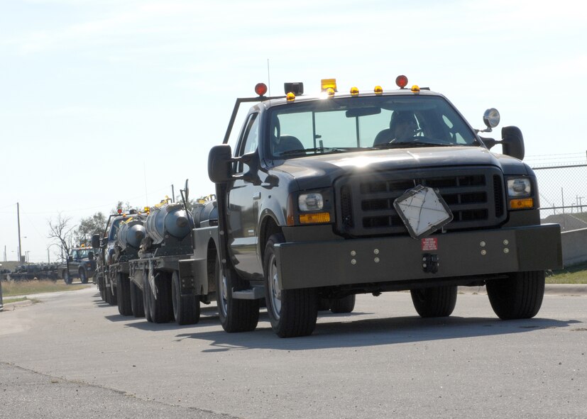 DYESS AIR FORCE BASE, Texas – Trucks loaded with munitions headed for the flightline roll through the gates of the “bomb dump” here Oct. 4. The CBUs, GBUs, and MK-84s on board armed Dyess B-1s for simulated combat sorties during this year’s Phase I Operational Readiness Inspection. (U.S. Air Force photo/Senior Airman Domonique Simmons)