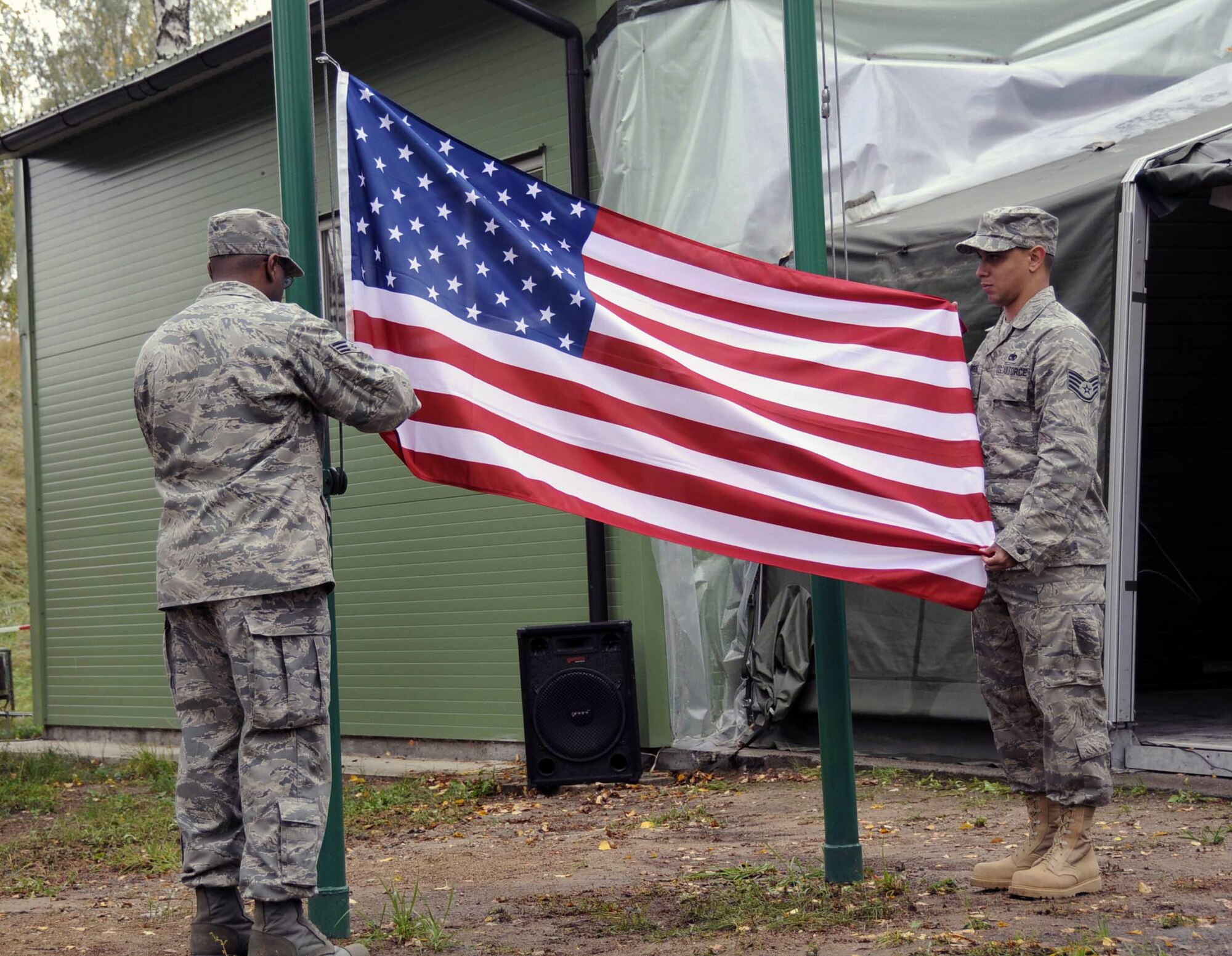 Senior Airman Antonio Huguley and Staff Sgt. Raphael Santos-Montanez raise the U.S. flag over the Quick Reaction Facility as part of the change-over ceremony marking the first day of the U.S. rotation performing the NATO Baltic air policing mission. Airman Huguley is assigned to the 493d Expeditionary Fighter Squadron PERSCO section. Sergeant Santos-Montanez is assigned to the 493d EFS Quality Assurance section. (U.S. Air Force photo/Tech. Sgt. Jill Lavoie)
