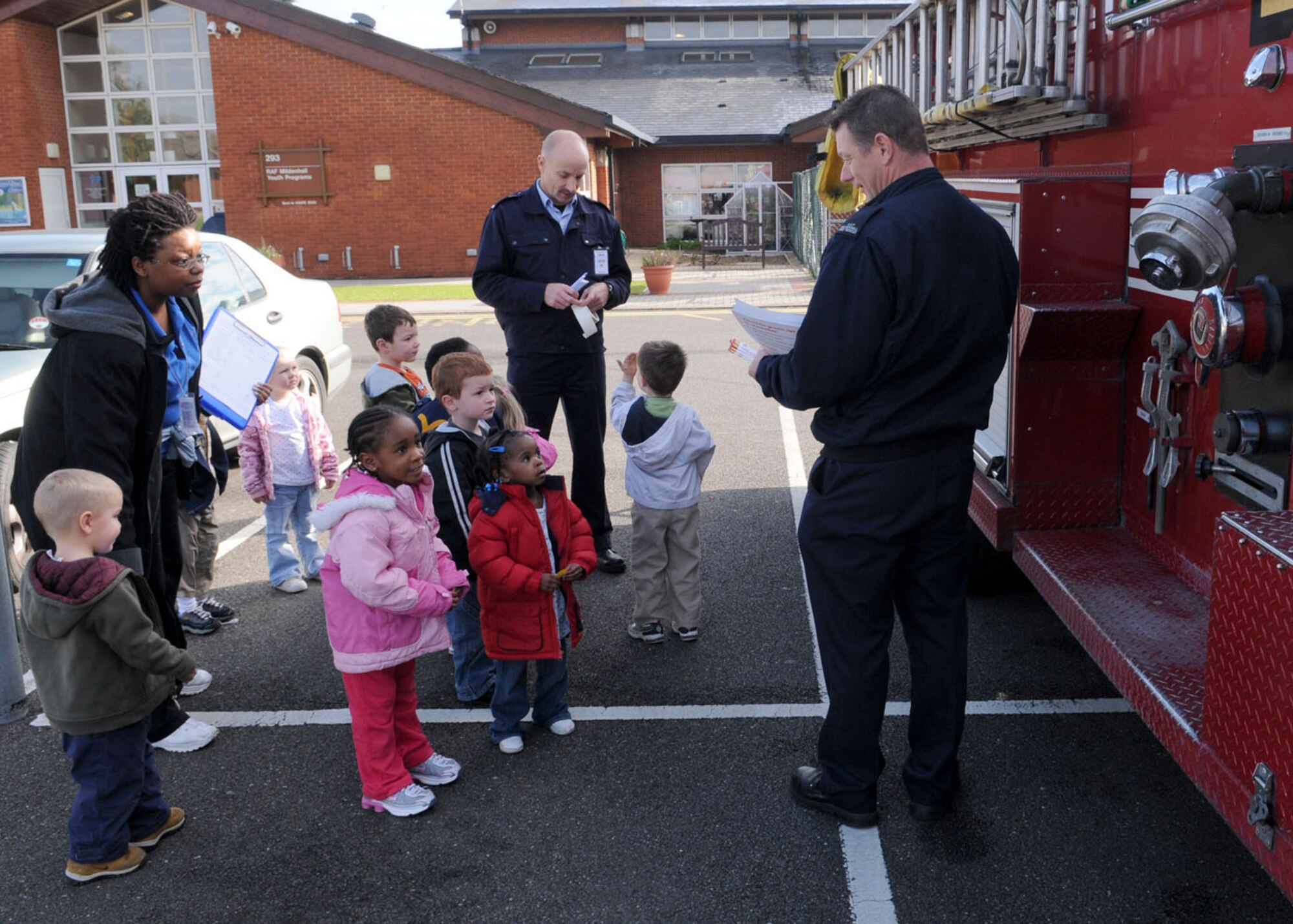 Military of Defence firefighters from the 100th Civil Engineer Squadron, Steve Tipler (center) and Barry Clark (right), show children from the Child Development Center around the fire truck Oct. 6, 2008, at RAF Mildenhall, England. The visit to the CDC was in support of “Fire Prevention Week” that takes place from Oct. 5 through 11. (U.S. Air Force photo by Staff Sgt. Jerry Fleshman)
