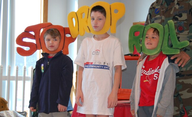 Devin Fox, Kyler Fox and Aydin Rodriguez show the rest of the children what to do if you ever catch on fire - stop, drop and roll.   The children from Scooby?s Den daycare were able to participate in a fire department demonstration for National Fire Safety Month. (Photo by Airman 1st Class Jessica Donnelly)
