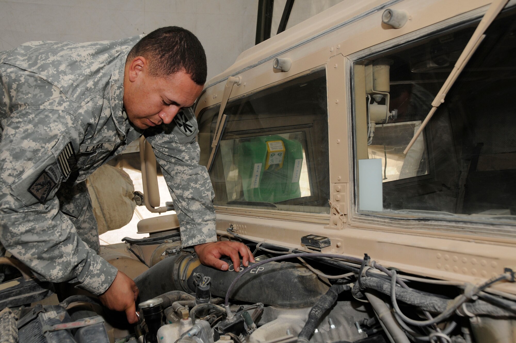 Spc. Michael Lara, wheel vehicle mechanic assigned to Alpha 243, installs an air conditioning unit in a High Mobility Multi-Wheeled Vehicle Oct. 4, 2008. Alpha 243 provides early warning and air defense support for personnel and resources at this undisclosed air base in Southwest Asia. Specialist Lara, a native of El Paso, Texas, is deployed from Fort Bliss, Texas, in support of Operations Iraqi and Enduring Freedom and Joint Task Force-Horn of Africa. (U.S. Air Force photo by Staff Sgt. Darnell T. Cannady/Released)