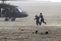 KUSAN AIR BASE, Republic Of Korea -- U.S. Air Force Staff. Sgt. Sergio Avalos, Survival, Evasion, Resistance and Escape specialist out of the 51st Operations Support Squadron, Osan Air Base, Republic of Korea, is rushed to a waiting HH-60 Pave Hawk helicopter out of Camp Humphreys, Republic of Korea, to fly by during the 2008 Gunsan Airshow here, Oct. 5. The San Benito, Texas native helped  entertain and educate more 250,000 people that were attracted to the two-day event held in the city of Gunsan, Oct. 4-5. (U.S. Air Force photo/Staff Sgt. Jason Colbert)