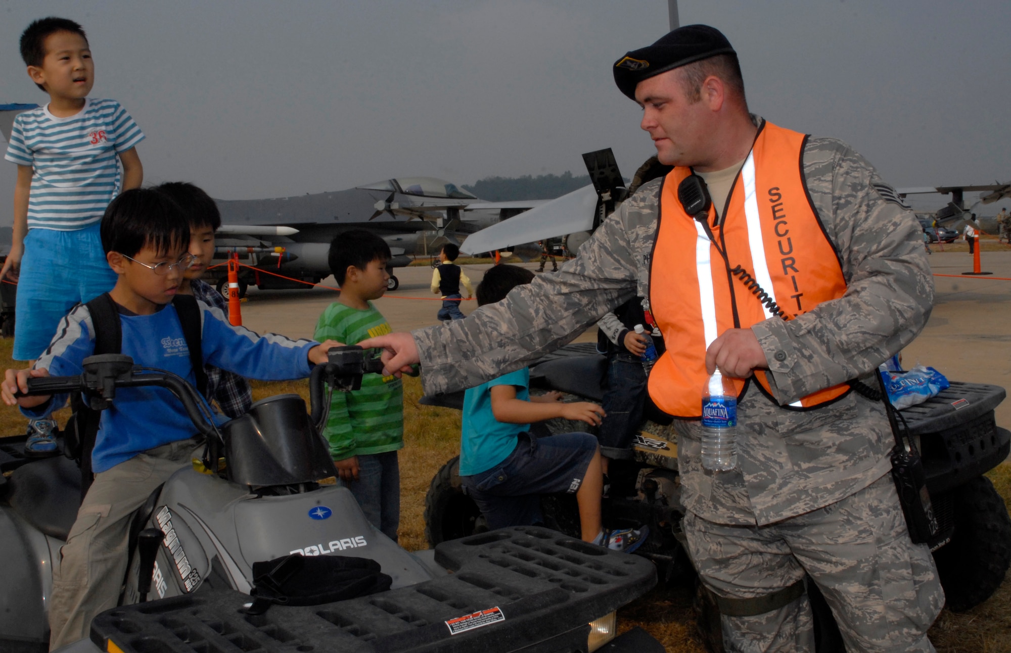 KUNSAN AIR BASE, Republic of Korea -- Staff Sgt. Joshua Phillips, 8th Security Forces Squadron Armory NCOIC, shows children from Gunsan City an All-Terrain Vehicle at the 2008 Gunsan Airshow static display area here, Oct. 4. Sgt. Phillips, a native of West Alexander, P.A., was one of the many patrolmen providing security at the static display site located on base. The City of Gunsan, 8th Fighter Wing and Republic of Korea Air Forces' 38th Fighter Group hosted the first partnership Air Show in Gunsan Oct. 4-5. (U.S. Air Force photo/Senior Airman Dana Hill) 