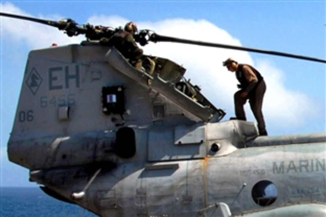 A U.S. Marine performs maintenance on a Sea Knight helicopter aboard the amphibious assault ship USS Iwo Jima, Oct. 1, 2008. Iwo Jima is deployed as part of the Iwo Jima Expeditionary Strike Group supporting maritime security operations in the U.S. 5th Fleet area of responsibility.