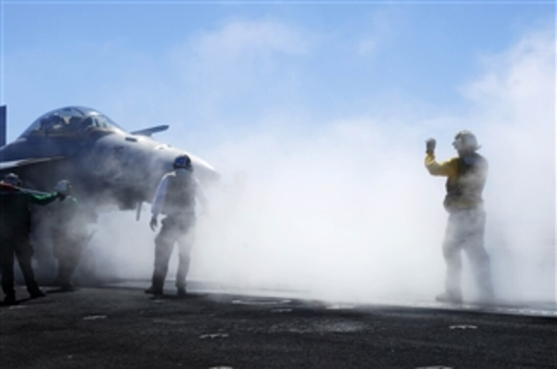 U.S. Navy Petty Officer 3rd Class Mike Condlin directs an F/A-18F Super Hornet from Strike Fighter Squadron 122 onto a catapult for launch from the flight deck of the aircraft carrier USS John C. Stennis (CVN 74) on Oct. 2, 2008.  The Stennis is conducting fleet replacement squadron carrier qualifications off the coast of California.  