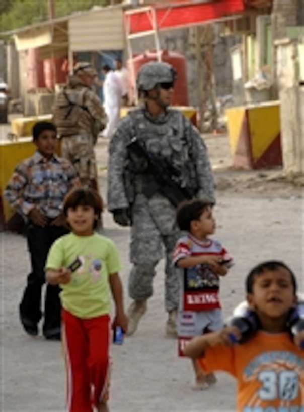 U.S. Army 2nd Lt. Caldwell, of the 21st Military Police Company (Airborne), is joined by a group of Iraqi children as he patrols their neighborhood and the area surrounding the Al Quibla Police Station in Basra, Iraq, on Oct. 2, 2008.  