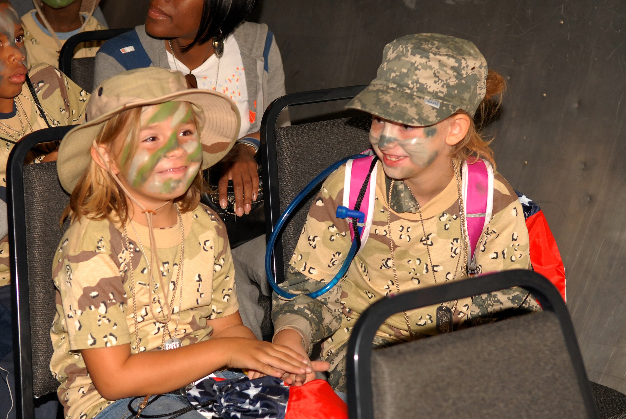 Amy Mutka (left), Daughter of Tech. Sgt. Steven Mutka, 17th Security Forces Squadron, and Aurora Jorell, daughter of Tech. Sgt. Craig Jorell, 316th Training Squadron, ride the mock C-130 Hercules flight from the Louis F. Garland Department of Defense Fire Academy to the War on Terrorism Training Camp during Operation KIDS Oct. 4. (U.S. Air Force photo by Senior Airman Kasabyan Musal)