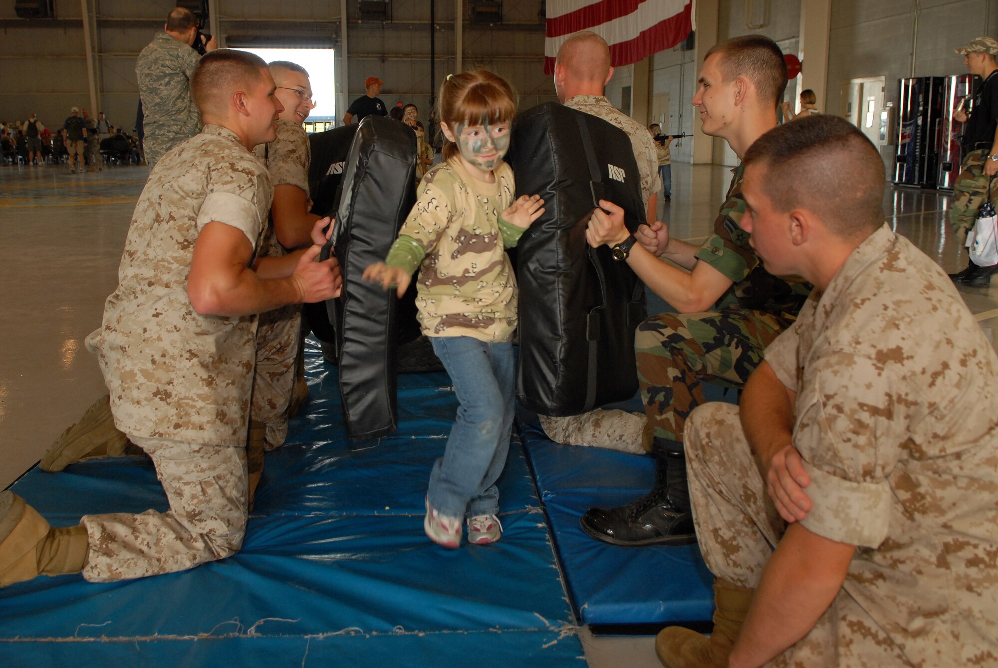 Busting her way through a blockade of Marines and Airmen at the Louis F. Garland Department of Defense Fire Academy during Operation KIDS Oct. 4 is Maranda Rose, daughter of Airman 1st Class Mikael Rose, 17th Security Forces Squadron. (U.S. Air Force photo by Senior Airman Kasabyan Musal)
