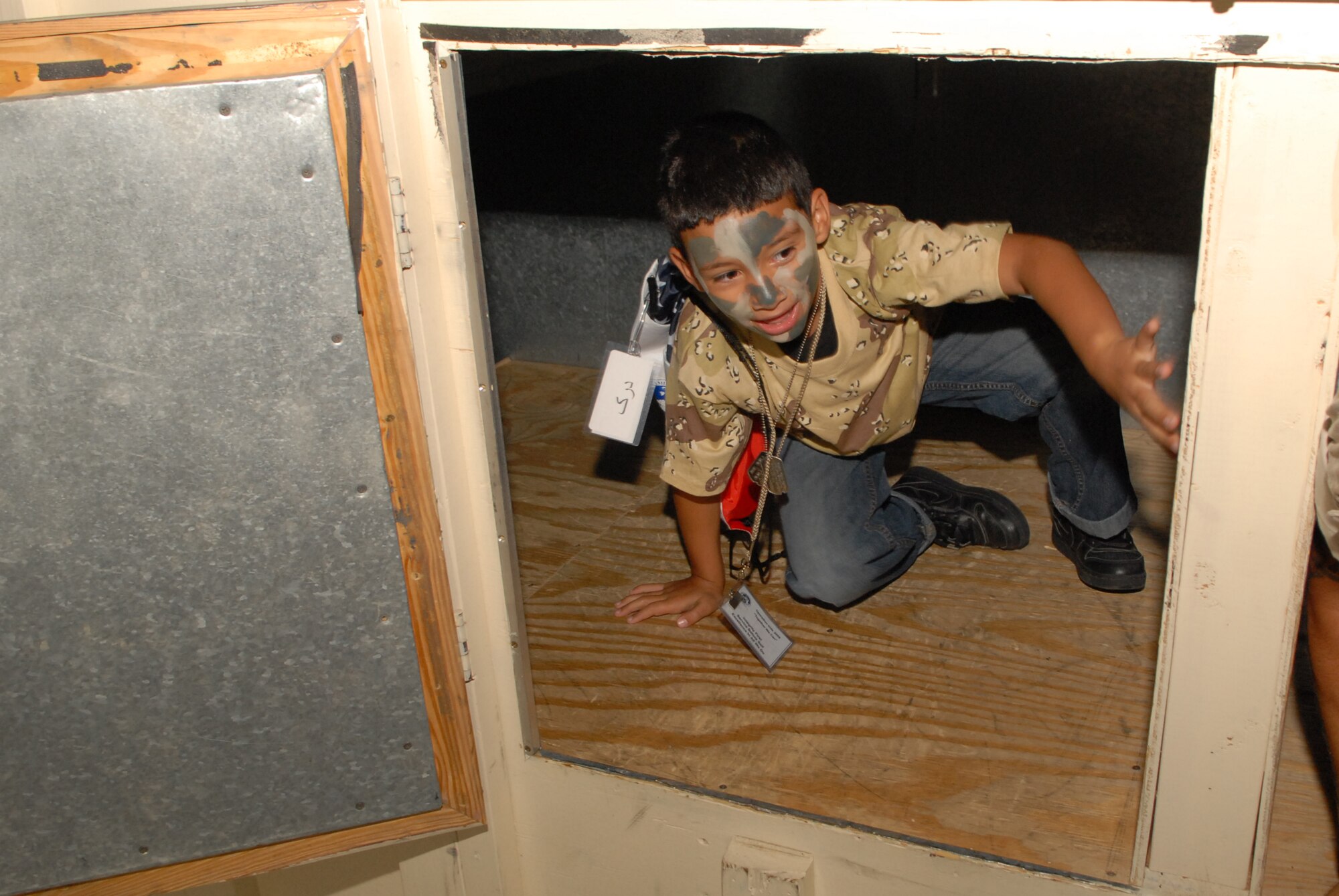 Climbing through the Enclosed Spaces Trainer at the Louis F. Garland Department of Defense Fire Academy during Operation KIDS Oct. 4 is Derek Alemany, son of Senior Airman Laura Garcia, 17th Security Forces Squadron. (U.S. Air Force photo by Senior Airman Kasabyan Musal)