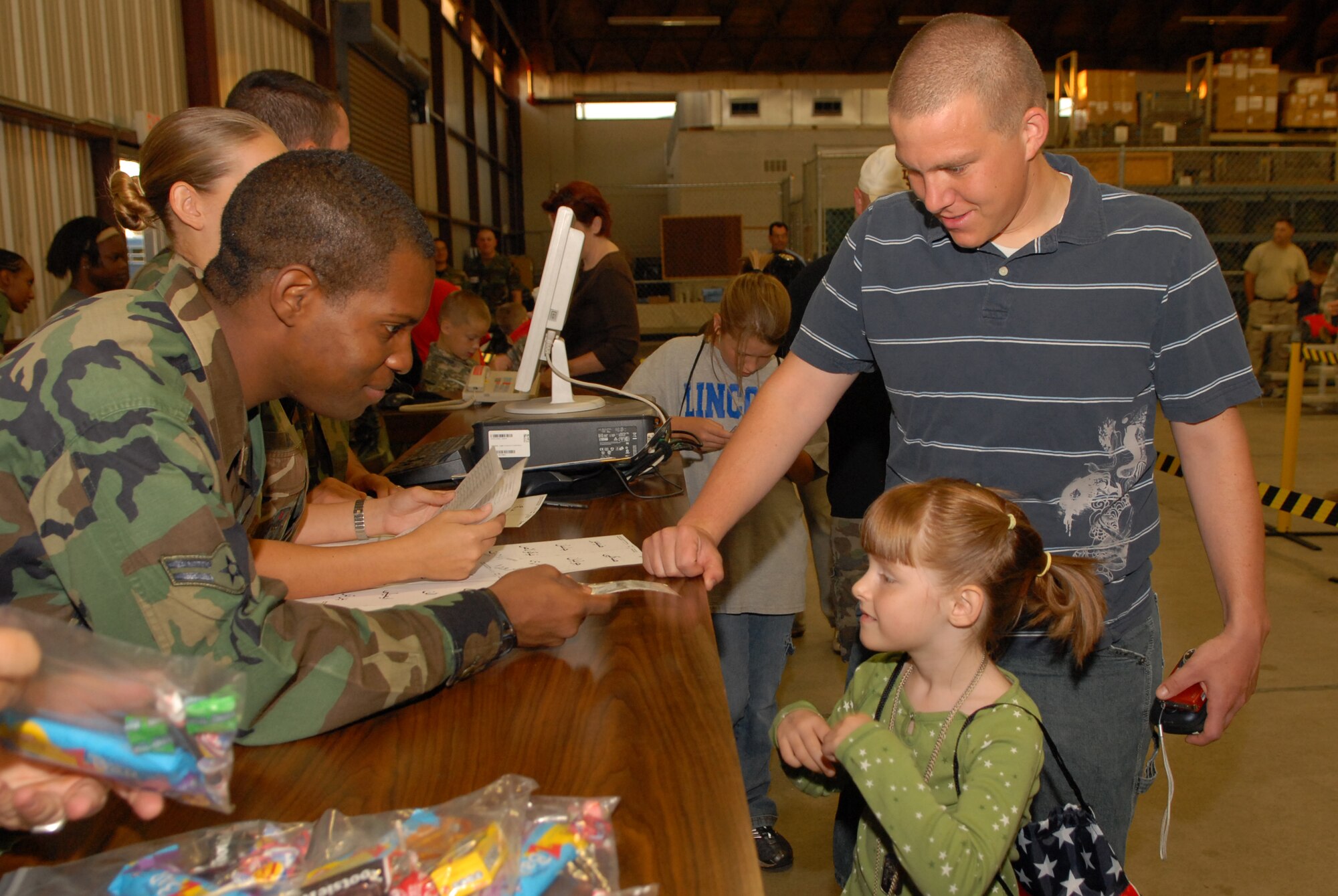 Airman 1st Class Jonathan Blythe, 17th Comptroller Squadron, briefs Maranda Rose and her father, Airman 1st Class Mikael Rose, 17th Security Forces Squadron, during Operation KIDS Oct. 4. (U.S. Air Force photo by Senior Airman Kasabyan Musal)
