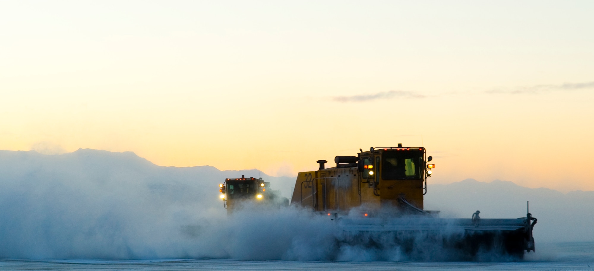 ELMENDORF AIR FORCE BASE, Alaska -- Members of the 3rd Civil Engineer Squadron Snow Removal Flight brush the snow off the flightline behind Hangar 18. (U.S. Air Force photo/Senior Airman Garrett Hothan)