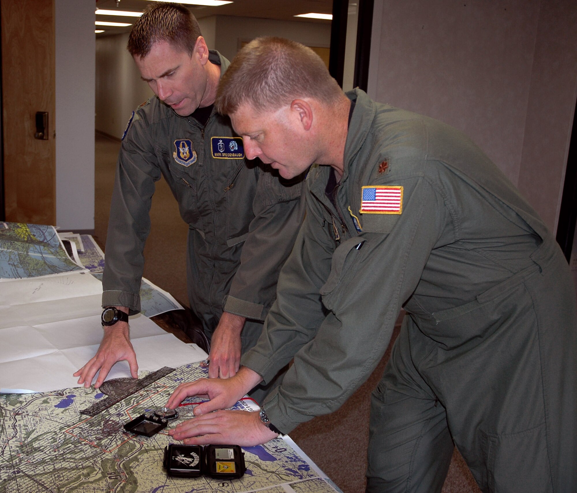 Majs. Mark Breidenbaugh (left) and Karl Haagsma discuss areas to be aerial sprayed over Terrebonne Parish, La. Their duties include identifying pests and areas to be aerial sprayed, prescribing correct treatment rates and flying on spray missions to ensure proper pesticide application. Majors Breidenbaugh and Haagsma are medical entomologists with Air Force Reserve Command's 910th Airlift Wing at Youngstown Air Reserve Station, Ohio. (U.S. Air Force photo/Capt. Brent J. Davis)