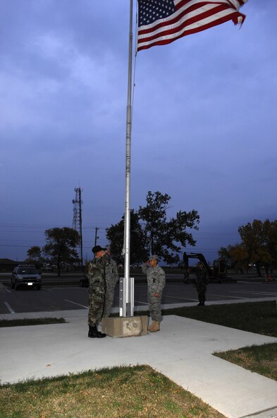 MINOT AIR FORCE BASE, N.D. — Tech. Sgt. Kenneth Kline (center), Senior Airman Charles Lewis (left),  Airman 1st Class Chris Reyes (right) and Staff Sgt. Daniel Coopman (far right) all salute the flag at half-staff here Oct.  5.  The Airmen, all firefighters from the 5th Civil Engineer Squadron, volunteered to perform the lowering in honor of the National Fallen Firefighters Memorial Weekend.  President George W. Bush approved legislation Oct. 16, 2001, requiring the American Flag to be lowered to half-staff on all federal buildings to memorialize fallen firefighters. (U.S. Air Force photo by Tech Sgt Lee A. Osberry Jr.)  