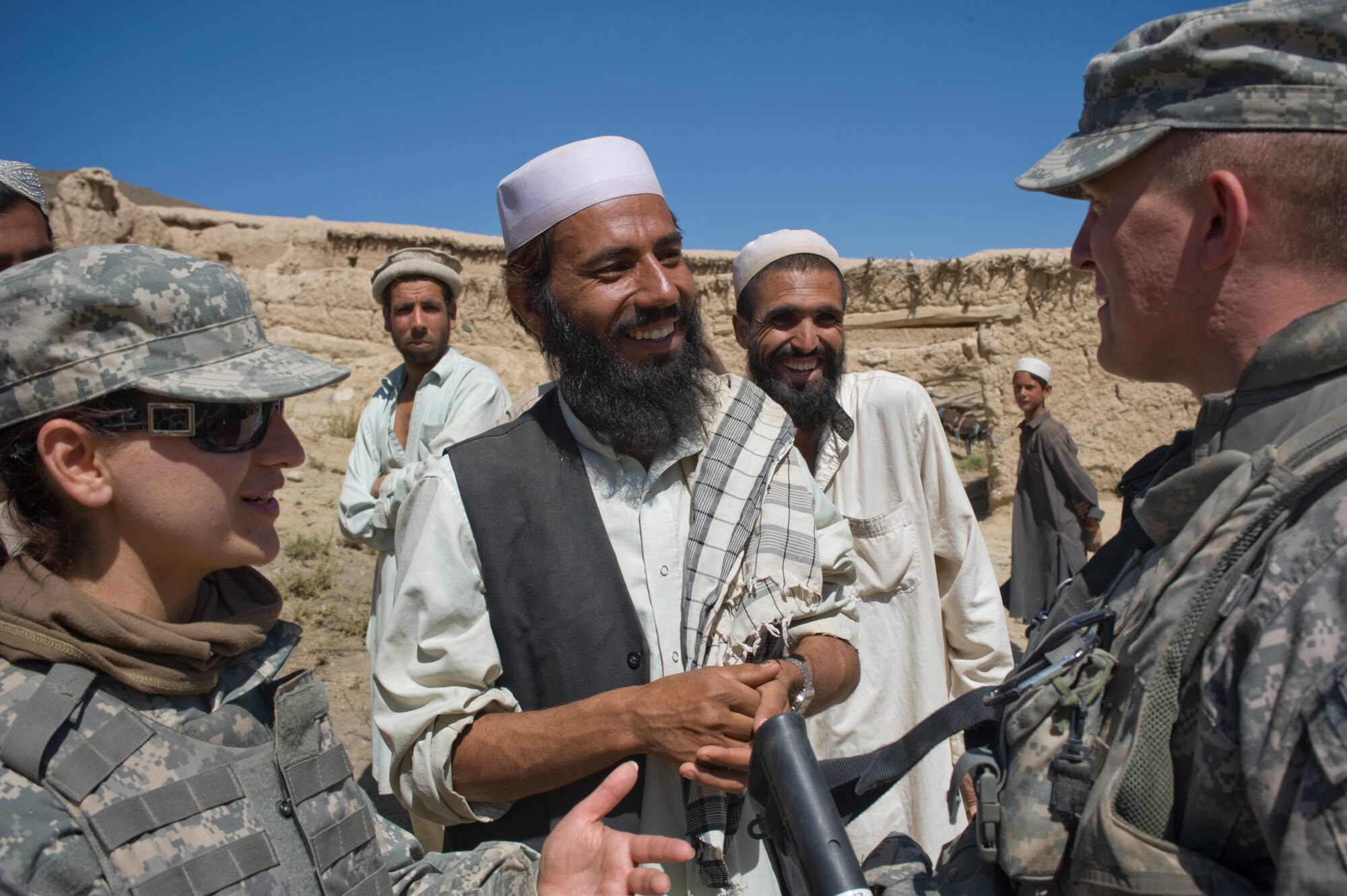 Molly, an interpreter, expresses the gratitude of village leaders to Army Capt. Steve Kaiser for providing medical services to village residents for the day. The joint-service team has members from the Air Force, Army and Navy assigned to it. Captain Kaiser is a Kapisa and Parwan Provincial Reconstruction Team civil affairs officer. (U.S. Air Force photo/Master Sgt. Keith Brown) 