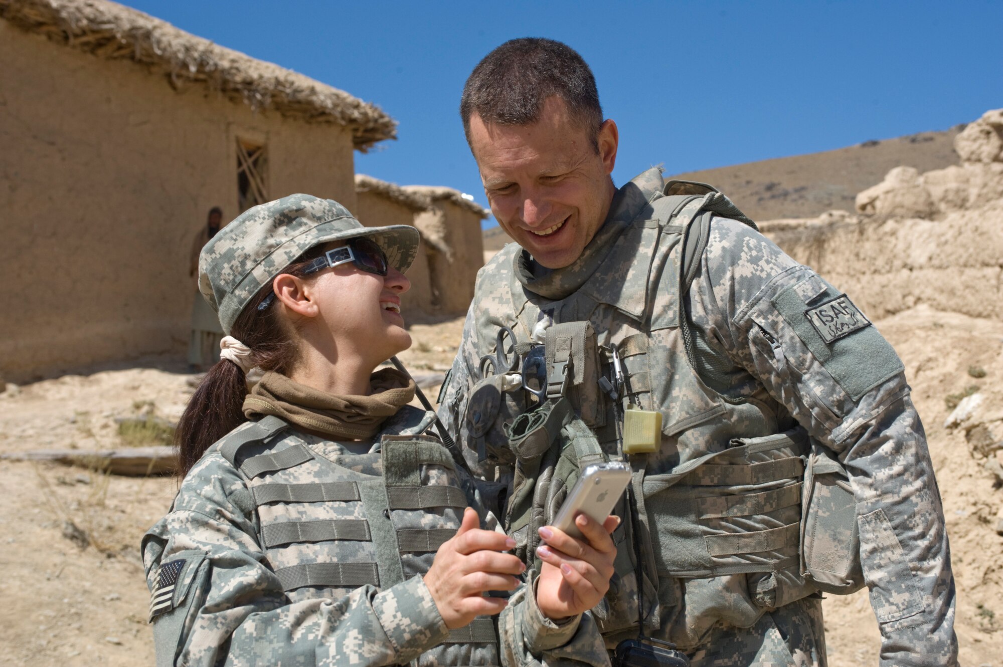 Molly, an interpreter, shares photos she took of village children with Capt. Marshall Fiscus.  The team traveled to Pacha Hawk to provide offer a medical clinic for residents. The joint-service team has members from the Air Force, Army and Navy assigned to it. Captain Fiscus is a Kapisa and Parwan Provincial Reconstruction Team medical professional. (U.S. Air Force photo/Master Sgt. Keith Brown) 