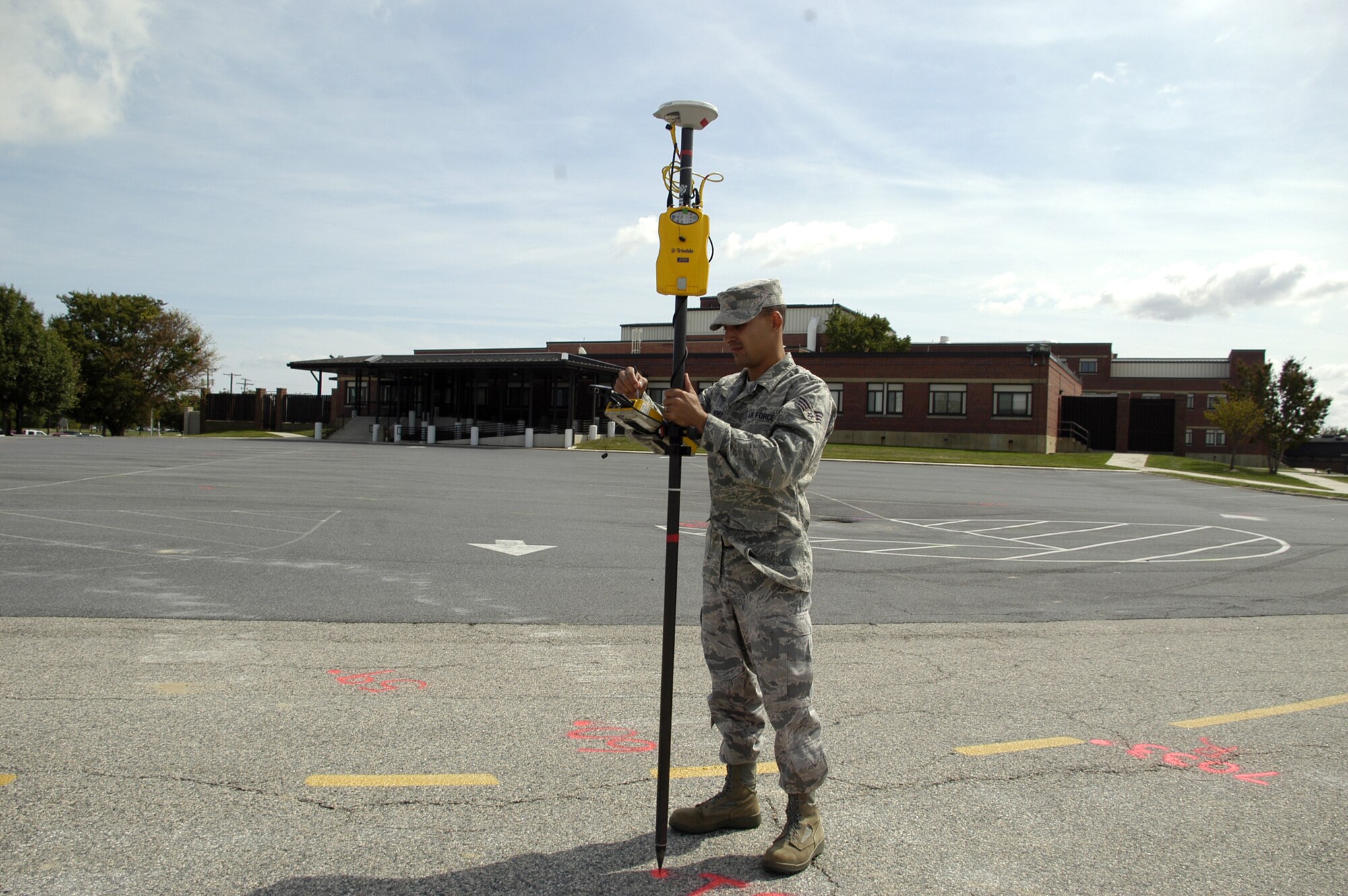 Senior Airman Yuslain Perez, 436th Civil Engineer Squadron, uses a Global Navigation Satellite System to survey the exact measurements of the hospital parking lot. This survey must be done to let the construction crew know where to build the new parking lot, which will provide increased parking capacity. The project is estimated to be completed in the early spring of 2009. (U.S. Air Force photo/ Airman 1st Class Shen-Chia Chu)