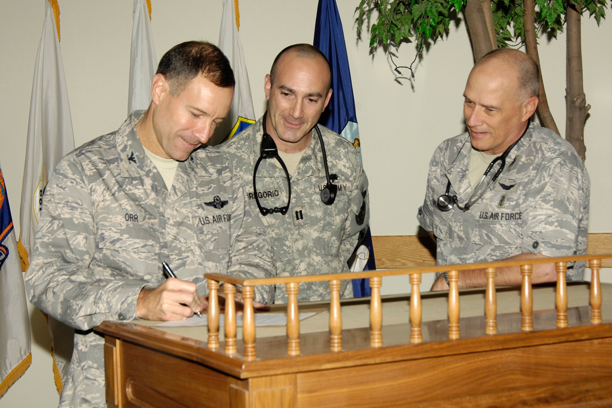 Col. David Orr, 66th Air Base Wing commander, signs a proclamation declaring Oct. 6 to 12 as Physician Assistants Week while the 66th Medical Group's physician assistants, Army Capt. David DiGregorio and Col. Randy Dobbins, 66 MDG commander, look on. (U.S. Air Force photo by Linda LaBonte Britt)