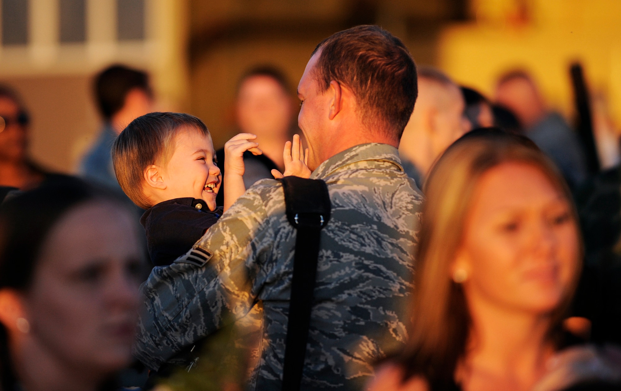 MOUNTAIN HOME AIR FORCE BASE, Idaho -- A father from the 389th Aircraft Maintenance Unit holds his giggling son for the first time in 4 months Oct. 6 after a deployment to Andersen AFB, Guam. More than 400 389th Aircraft Maintenance Unit personnel supported the flying mission of 18 F-15E Strike Eagles deployed to Guam to provide flexible air-to-air and air-to-ground attack capabilities over the Pacific. (U.S. Air Force photo by Airman 1st Class Ryan Crane)