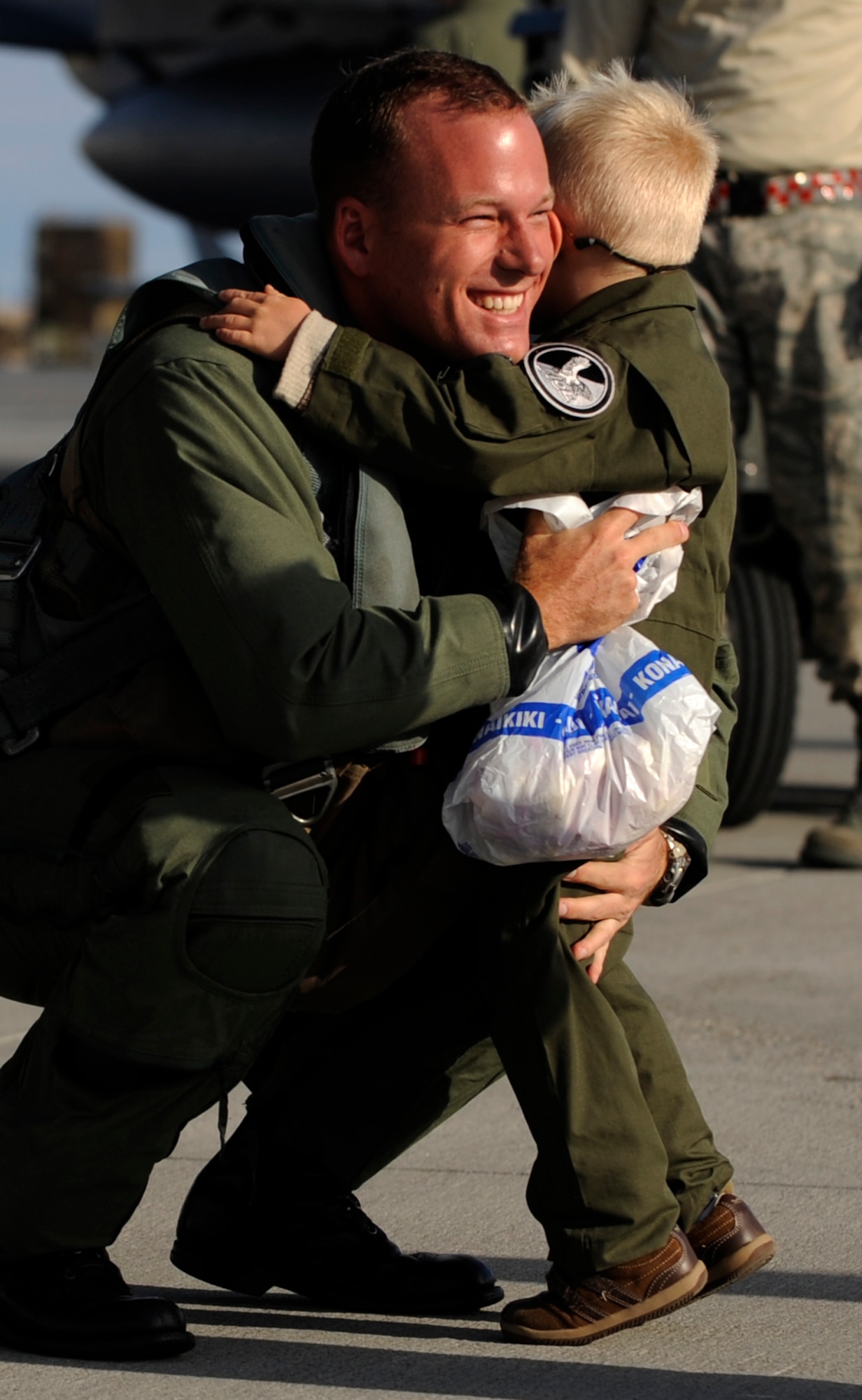 MOUNTAIN HOME AIR FORCE BASE, Idaho -- Major Grant Bucks, 389th F-15E Strike Eagle pilot, shares a moment with his son after landing at the base, Oct. 6. Members of the 389th Thunderbolts returned from a four-month long deployment to Andersen AFB, Guam where they provided flexible air-to-air and air-to-ground attack capabilities over the Pacific. (U.S. Air Force Photo/ Airman 1st Class Stephany Miller)