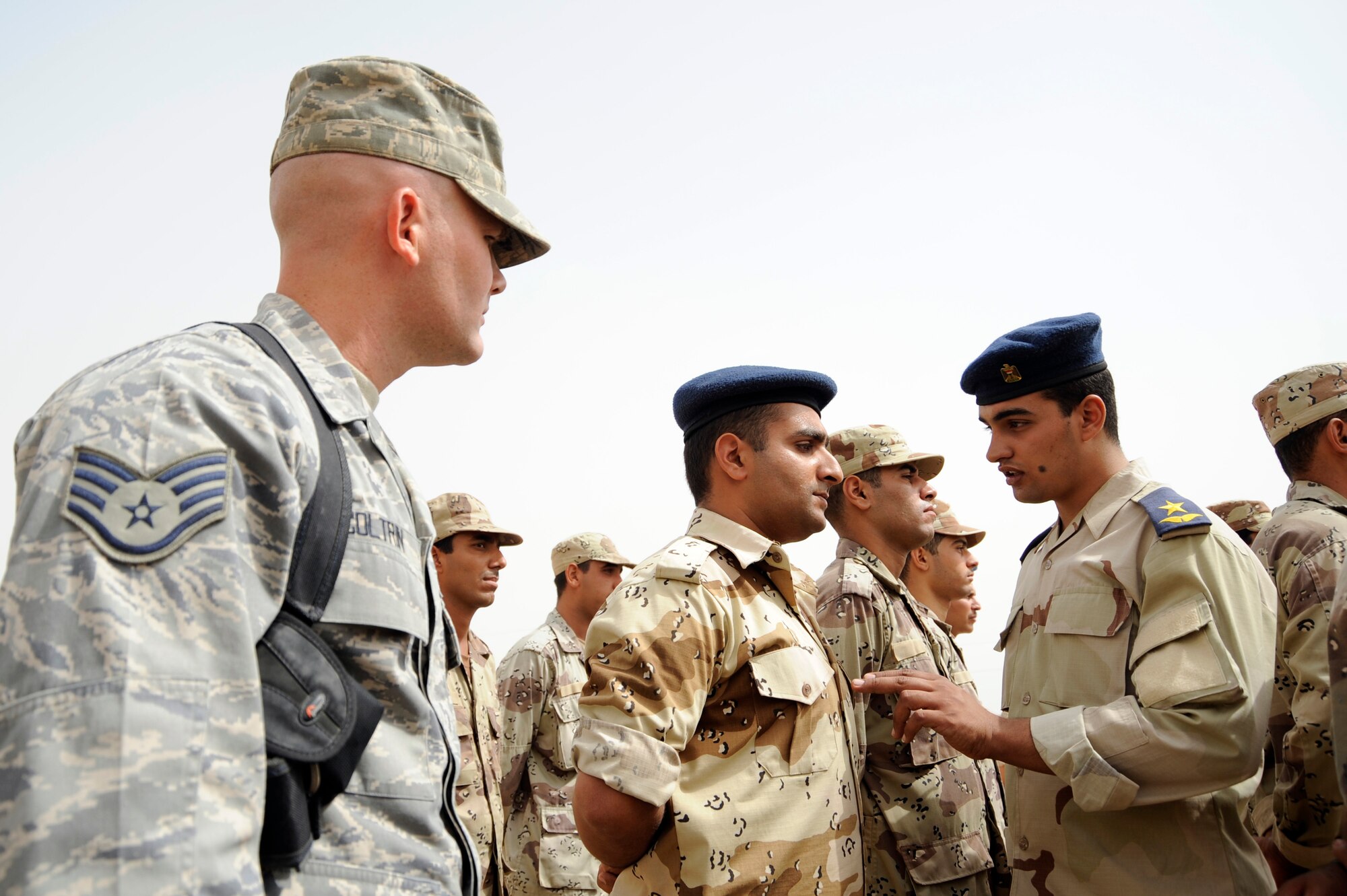 AL TAJI AIR BASE, Iraq -- U.S. Air Force Staff Sgt. Matthew Coltrin, left, a military training instructor air advisor, 370th Expeditionary Training Squadron, watches Iraqi air force Lt. Ali, right, military training instructor, explain the importance of military bearing to a warrant officer during parade practice. (U.S. Air Force photo/Staff Sgt. Paul Villanueva II)